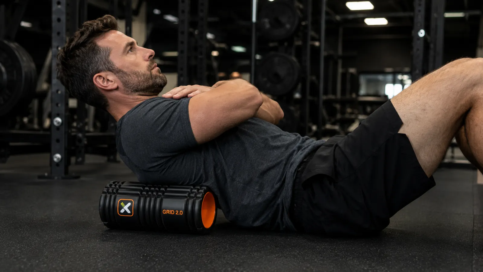 Person using the TriggerPoint GRID 2.0 foam roller on their upper back on a yoga mat